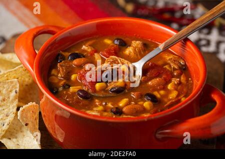 Wholesome taco chicken soup with warm tones served with tortilla chips Stock Photo