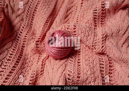 ball of pink wool on a knitted pink sweater Stock Photo
