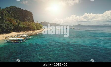 Sun sand beach at green mountain island aerial. Passenger boats at tropic paradise isle nature landscape. Amazing greenery exotic plants and trees. People admire tropical cruise Stock Photo