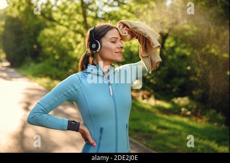 Training in park, woman listens to music Stock Photo