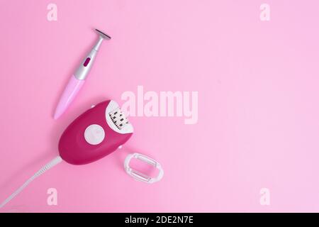 electric epilator and foot trimer on a pink background, taking care of yourself at home . space for text, top view. Stock Photo