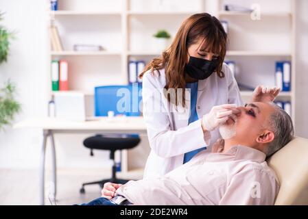 Old man visiting female doctor for plastic surgery Stock Photo