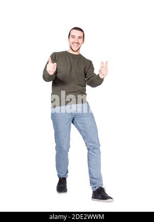Full length portrait of joyful and carefree young man in a dancing move, points forefingers to camera, smiling broadly. Stylish contented guy greeting Stock Photo