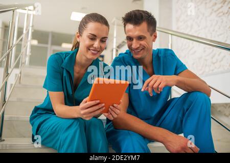 Two medical workers watching something on internet and discussing Stock Photo