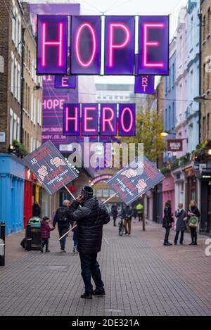 London, UK.  28 November 2020.  An anti-lockdown protester carries signs through Carnaby Street.  England is due to come out of lockdown on 2 December as the coronavirus pandemic continues.  Credit: Stephen Chung / Alamy Live News Stock Photo
