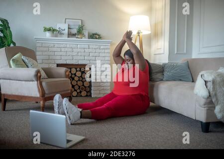 Plus size african american woman having an online yoga class Stock Photo