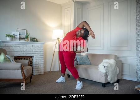 Plus size african american woman doing leaning to the sides Stock Photo