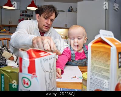 Father and child painting in the kichen.  photo Bo Arrhed Stock Photo