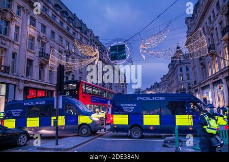 London, UK. 28th Nov, 2020. Police block the top of Regent Street under the Christmas Angels - The protest organised by Stand Up X regroups in Hyde Park and then Heads off down OXford Street once more. They question whether the whole covid pandemic is a hoax and believe the scientists, who agree with them, are shut out of the media. Credit: Guy Bell/Alamy Live News Stock Photo