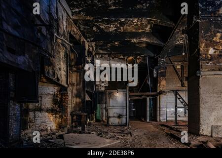 Burnt and ruined interior of industrial building after fire. Consequences of war, fire or other disaster. Stock Photo