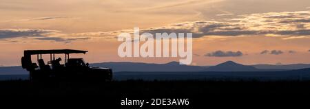 Africa, Kenya, Northern Serengeti Plains, Maasai Mara. Mara sunrise with safari jeep silhouette. Stock Photo