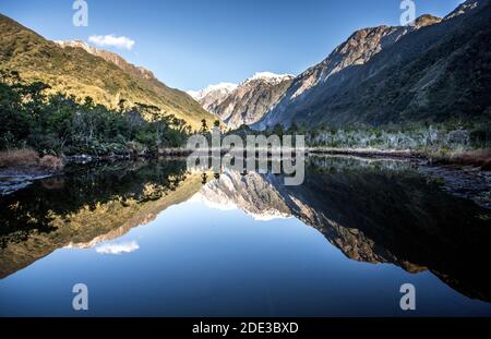 Lake Matheson providing stunning reflections of New Zealand's highest peaks - Aoraki (Mount Cook) and Mount Tasman. Stock Photo