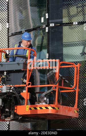 A glazier working at heights on a construction site at the University of Central Lancashire in Preston Stock Photo