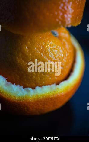 Still life of an orange wrapped in orange peel Stock Photo