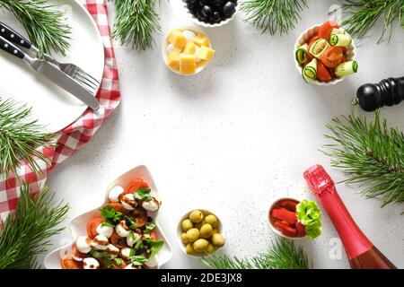 Concept of Christmas dinner with salads and various vegetables dishes for festive Xmas party on white table. View from above. Space for text. Stock Photo