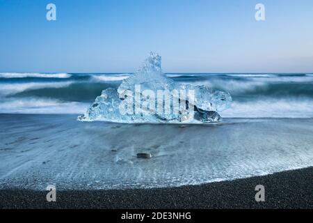 Chunk of ice on sea shore at Diamond beach near Jokulsarlon Glacier Lagoon, Iceland Stock Photo