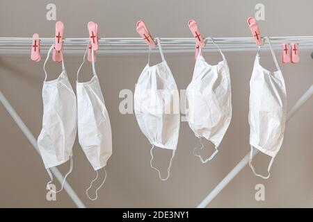 Used and washed face masks hanging on drying rack Stock Photo