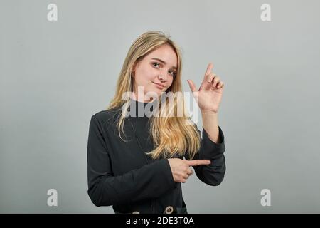 Shapes big object with two hands, gasps from surprise, holding palms in front and showing size something, holds empty open, indicate dimension while, demonstrating of item, for your text design inside Stock Photo