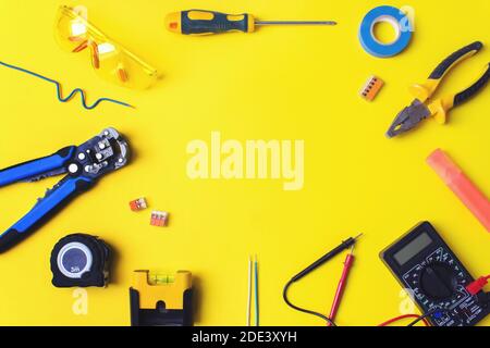 Set of electrician's tools on yellow background. Flat lay composition with electrician's tools and space for text yellow background Stock Photo