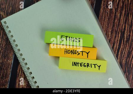 Ethics, Honesty, Integrity text on sticky notes isolated on green desk. Mechanism Strategy Concept Stock Photo