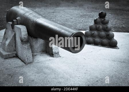 A Civil war era cannon exhibit along with a stack of cannon balls,  a historical display in St. Augustine, FL, in selenium tone Stock Photo