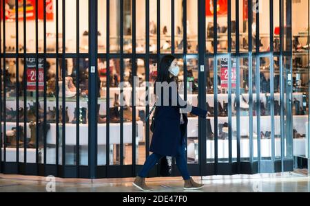 Mississauga, Canada. 28th Nov, 2020. A woman wearing a face mask walks past a closed store at Square One Shopping Center in Mississauga, Ontario, Canada, on Nov. 28, 2020. As of Saturday evening, Canada reported a total of 364,810 COVID-19 cases and 11,976 deaths, according to CTV. Credit: Zou Zheng/Xinhua/Alamy Live News Stock Photo