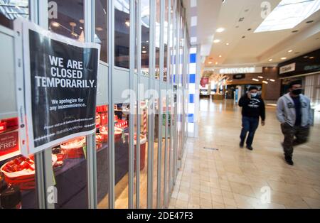 Mississauga, Canada. 28th Nov, 2020. People wearing face masks walk past a closed store at Square One Shopping Center in Mississauga, Ontario, Canada, on Nov. 28, 2020. As of Saturday evening, Canada reported a total of 364,810 COVID-19 cases and 11,976 deaths, according to CTV. Credit: Zou Zheng/Xinhua/Alamy Live News Stock Photo