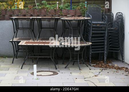 Stacked tables and chairs on the restaurant terrace during lockdown due to coronavirus pandemic Stock Photo
