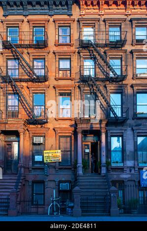 Fire escapes on tenement apartment buildings in Harlem neighborhood, New York City. Stock Photo