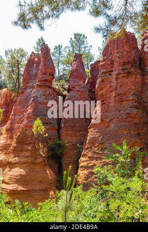 Red pyramid-shaped rocks in the natural park of ochre rocks in Roussillon, Luberon, Provence, France Stock Photo