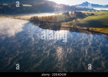 Wafts of fog at Irrsee lake with fishing boat and view into Mondseeland, ground fog, from above, drone photo, aerial photo, Salzkammergut, Upper Stock Photo