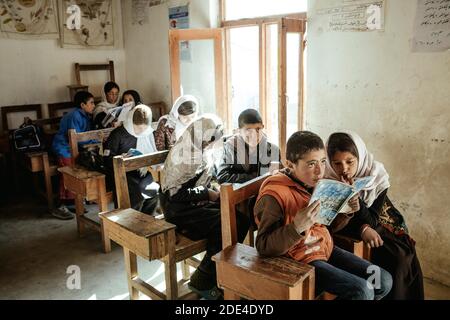 Children in a classroom, a girl and a boy reading together from an exercise book, Potokh Primary School, Potokh, Wakhan Corridor, Afghanistan Stock Photo