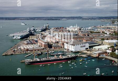 Aerial view of the Royal Navy dockyard in Portsmouth, Hampshire on a sunny summer day.  Aerial view including HMS Warrior, and the aircraft carriers H Stock Photo