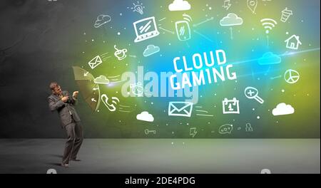Businessman defending with umbrella from CLOUD GAMING inscription, modern technology concept Stock Photo