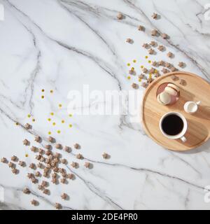 Flat lay composition of coffee, milk and macarons on wooden tray on side with gold sparkles Stock Photo