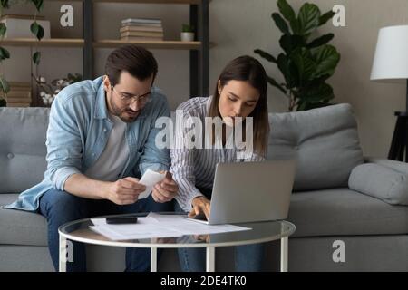 Young couple pay bills manage household family expenses Stock Photo