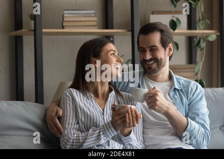 Happy couple relax on sofa drinking tea Stock Photo