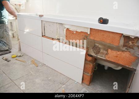 An unfinished bath tub installation with ceramic tiles in house bathroom. Stock Photo