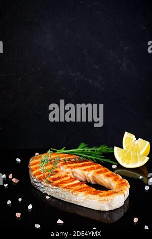 Grilled salmon fish on stone board. Salt atlantic salmon fried on grill with lemon Stock Photo