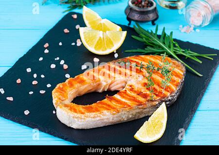 Grilled salmon fish on stone board. Salt atlantic salmon fried on grill with lemon Stock Photo