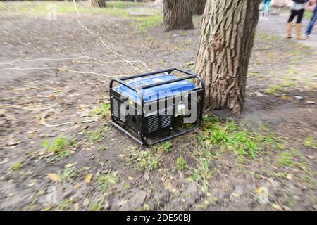 A backup portable generator is producing power, electricity outdoors during a fair. Stock Photo