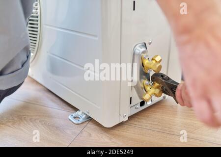 Installing an air conditioner in an apartment office, close-up of an technician hands Stock Photo