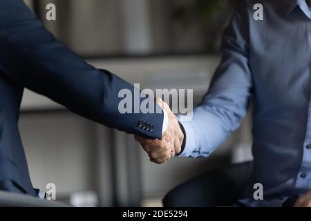 Two businessmen in formal suits shaking hands after successful negotiations Stock Photo