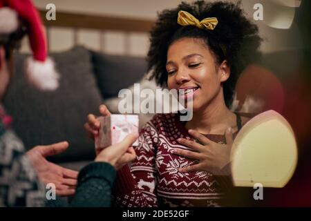 thankful  young afro-american female receiving present from a friend Stock Photo