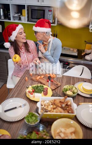 A daughter enjoying getting lesson on preparing A Xmas meal from mother in a festive atmosphere. Christmas, family, together Stock Photo