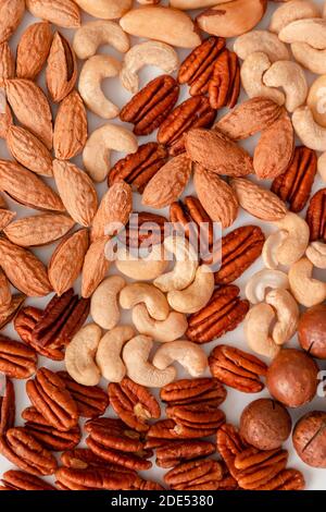 Proper nutrition composition of assorted nuts pattern vertical photo for banner, article or packaging. Pecans, brazil nuts, cashews, almonds and macadamia nut Stock Photo