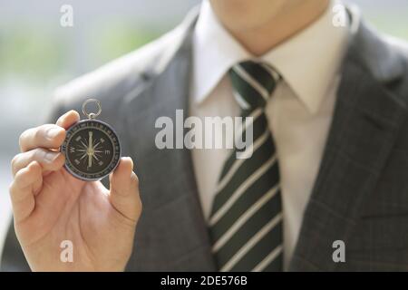 Close up of businessman holding Compass Stock Photo