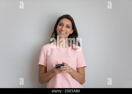 Portrait of millennial indian arab woman with smartphone in hands. Stock Photo