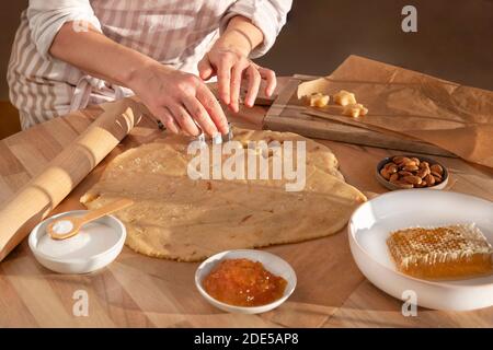 A woman bakes traditional star-shaped Christmas biscuits at home Stock Photo