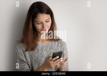 Pretty young caucasian woman using modern smartphone gadget. Stock Photo